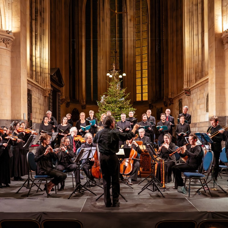 Orkest in een kerk met kerstboom op de achtergrond