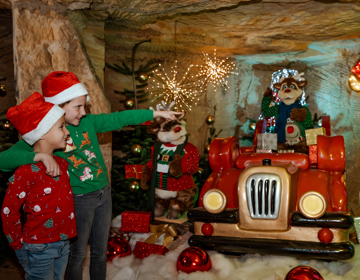 Twee kinderen in kerstkleding in de kerstgrotten van Valkenburg