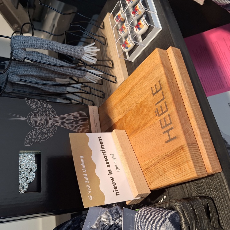 Een houten serveerplank met Heële omringd met andere cadeautjes uit de streek. 