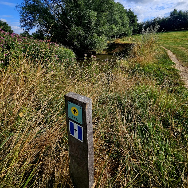 Knopen Lopen paaltje met daarop de Geuldalpad markering op een wandelpad langs de Geul.