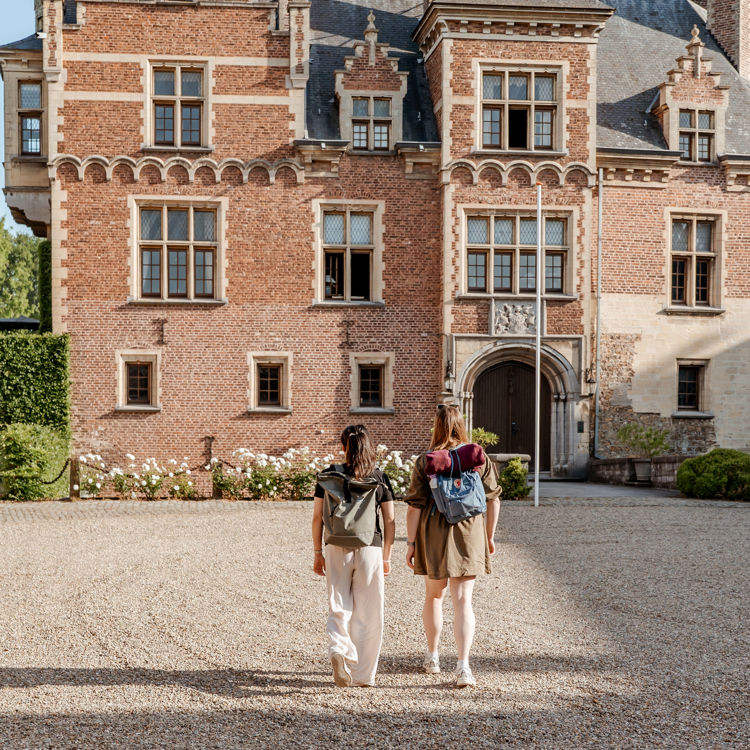 Twee wandelaars in zomerkleding wandelen door de zon bij kasteel mheer met een rugzak
