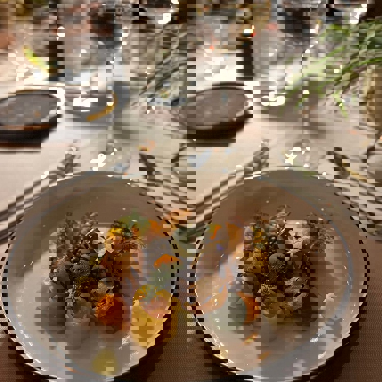 Een bord met een vegetarisch of vega gerecht met wijnglas en gedekte tafel