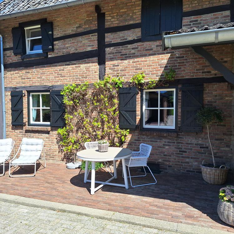 Terras met tafel en ligstoelen van een B&B vakwerkhuis in de zon 