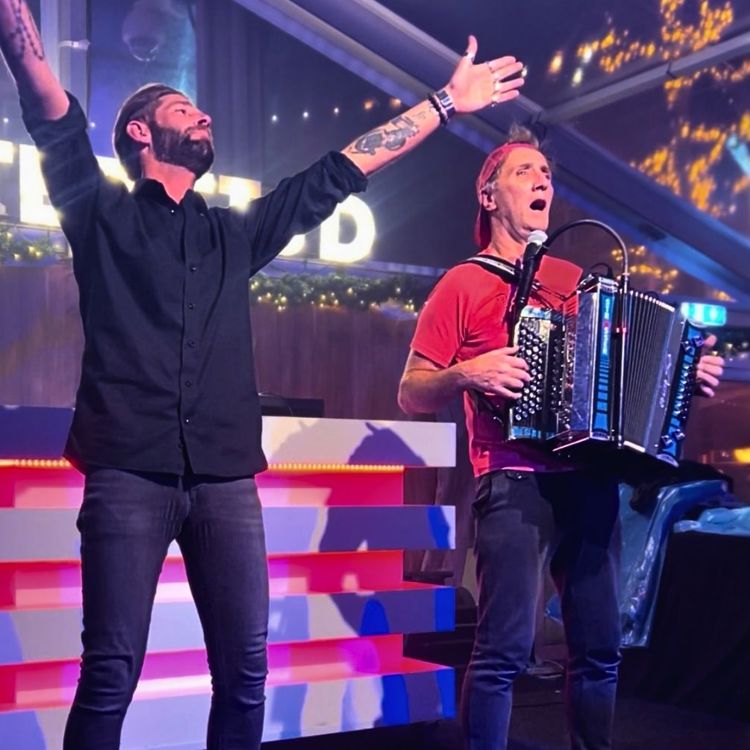 Twee mensen op podium waarvan een met accordeon